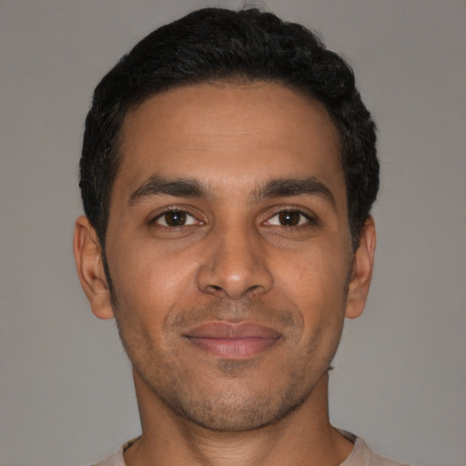 Joyful latino young-adult male with short  brown hair and brown eyes