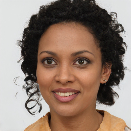 Joyful black young-adult female with long  brown hair and brown eyes