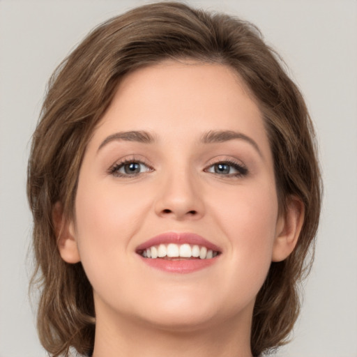 Joyful white young-adult female with medium  brown hair and green eyes