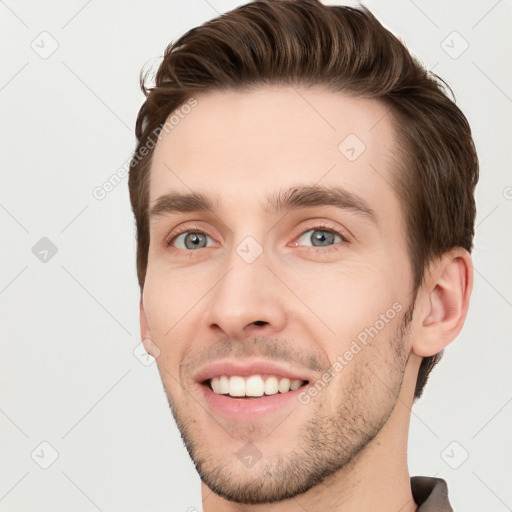 Joyful white young-adult male with short  brown hair and grey eyes