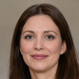 Joyful white adult female with long  brown hair and brown eyes