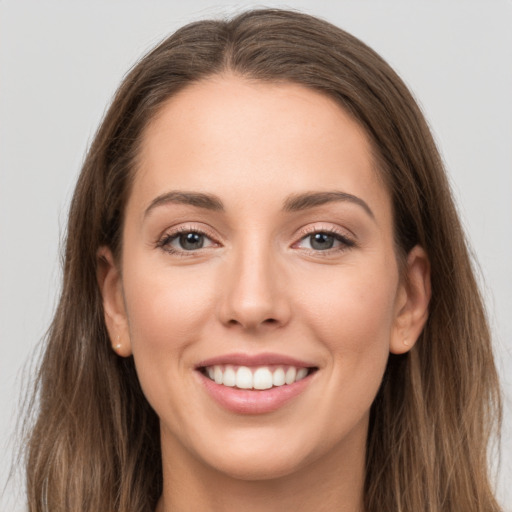 Joyful white young-adult female with long  brown hair and grey eyes