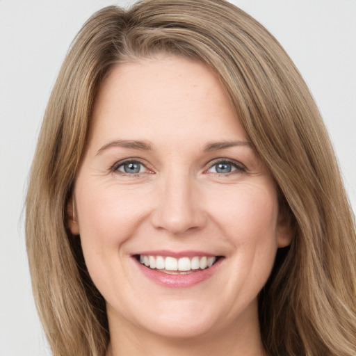 Joyful white young-adult female with long  brown hair and green eyes