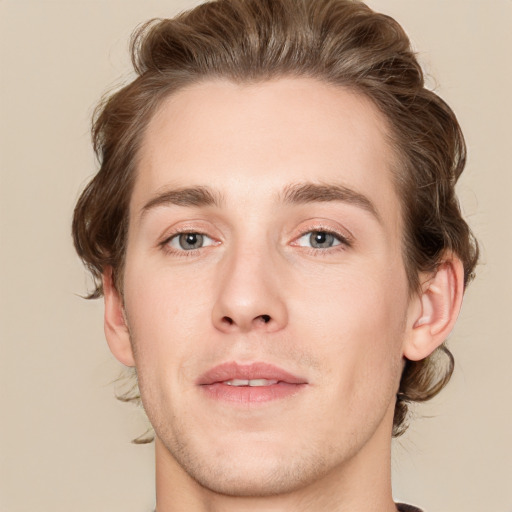 Joyful white young-adult male with medium  brown hair and grey eyes