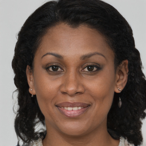 Joyful latino adult female with medium  brown hair and brown eyes