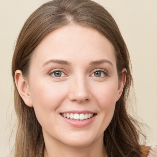 Joyful white young-adult female with long  brown hair and blue eyes