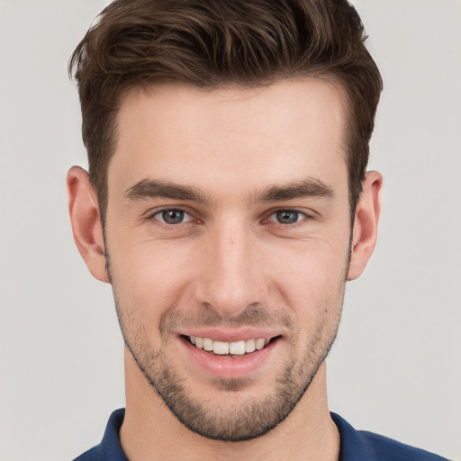 Joyful white young-adult male with short  brown hair and grey eyes