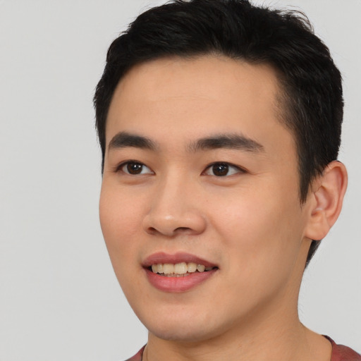 Joyful asian young-adult male with short  black hair and brown eyes