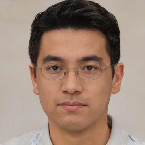 Joyful asian young-adult male with short  black hair and brown eyes