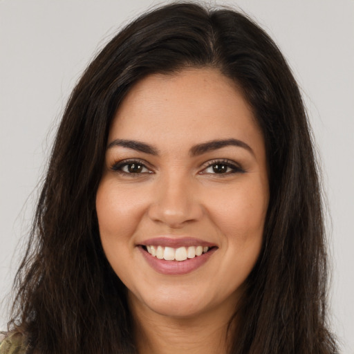 Joyful latino young-adult female with long  brown hair and brown eyes