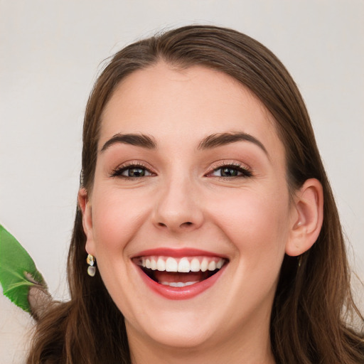 Joyful white young-adult female with long  brown hair and green eyes