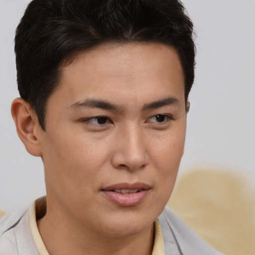 Joyful asian young-adult male with short  brown hair and brown eyes