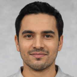 Joyful latino young-adult male with short  black hair and brown eyes