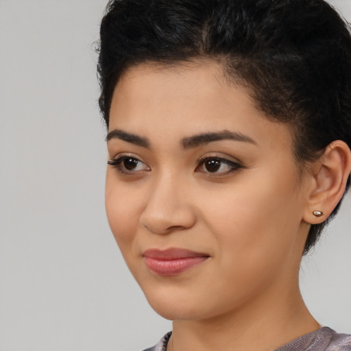 Joyful latino young-adult female with short  black hair and brown eyes
