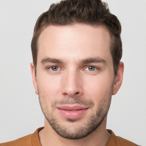 Joyful white young-adult male with short  brown hair and grey eyes