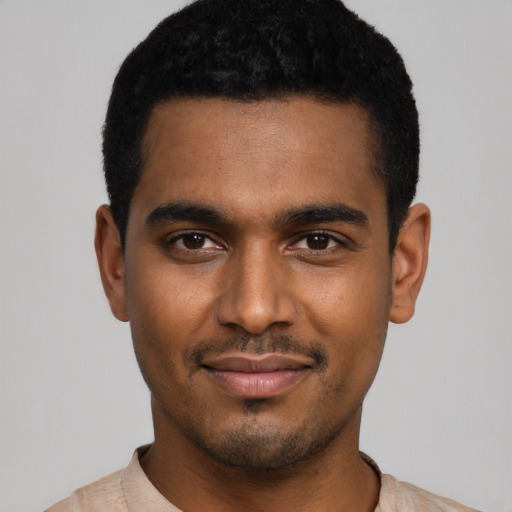Joyful black young-adult male with short  black hair and brown eyes