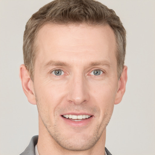 Joyful white adult male with short  brown hair and grey eyes