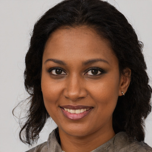 Joyful black young-adult female with medium  brown hair and brown eyes