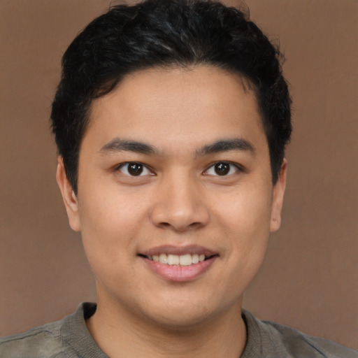 Joyful latino young-adult male with short  brown hair and brown eyes