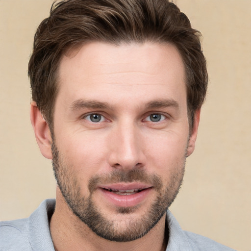 Joyful white young-adult male with short  brown hair and grey eyes