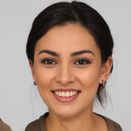 Joyful latino young-adult female with medium  brown hair and brown eyes