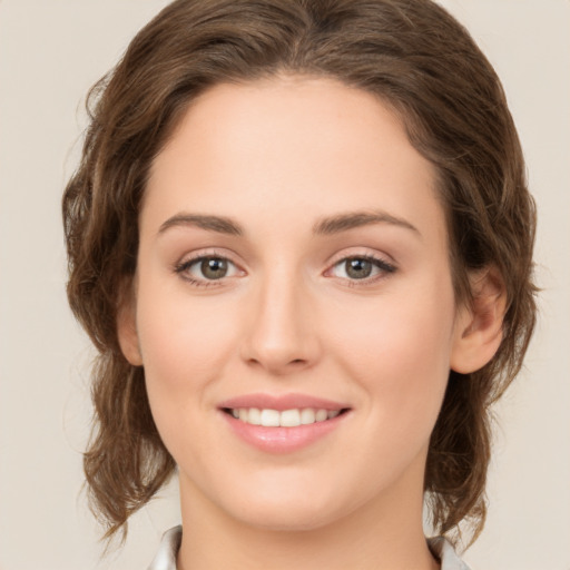 Joyful white young-adult female with medium  brown hair and green eyes