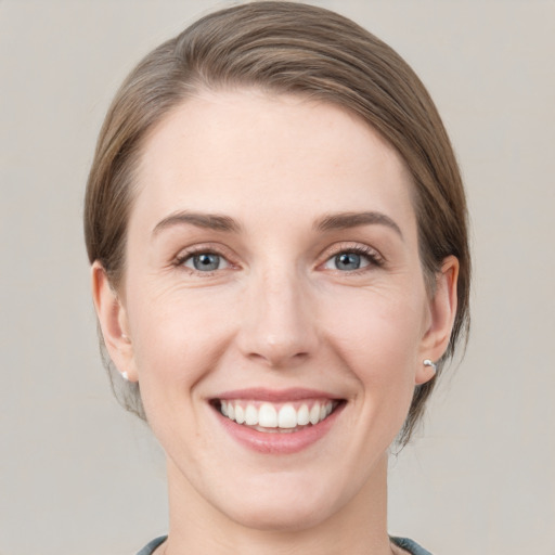 Joyful white young-adult female with medium  brown hair and grey eyes