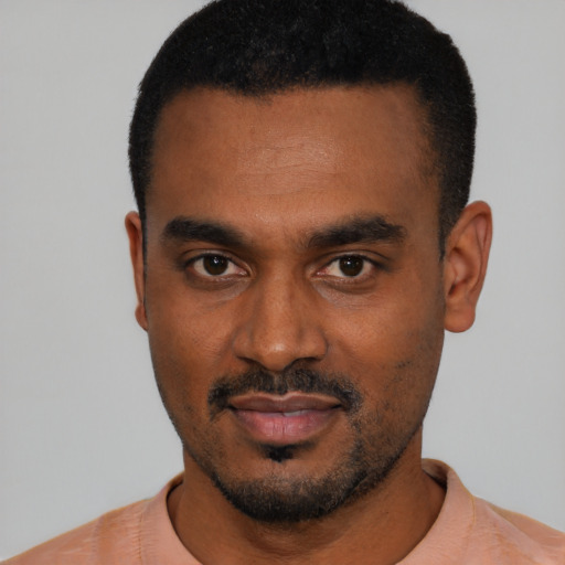 Joyful black young-adult male with short  black hair and brown eyes