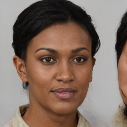 Joyful black young-adult female with medium  brown hair and brown eyes