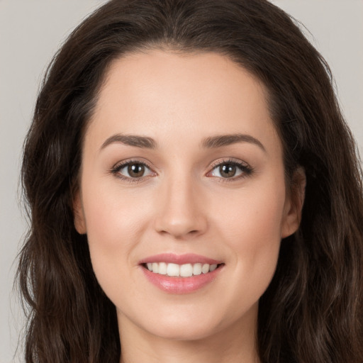 Joyful white young-adult female with long  brown hair and brown eyes