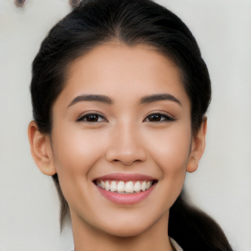 Joyful latino young-adult female with medium  brown hair and brown eyes