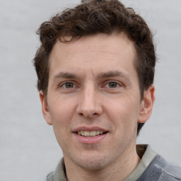 Joyful white adult male with short  brown hair and grey eyes