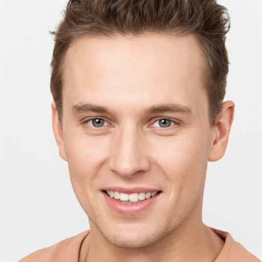 Joyful white young-adult male with short  brown hair and grey eyes