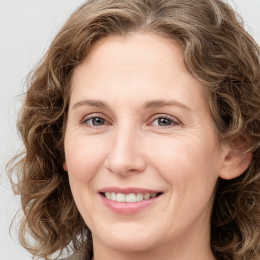 Joyful white young-adult female with long  brown hair and green eyes