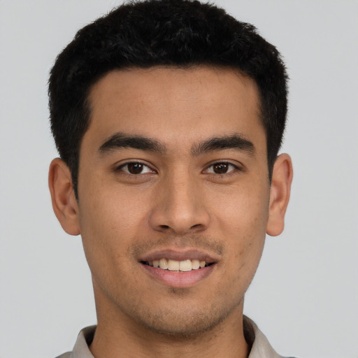 Joyful latino young-adult male with short  black hair and brown eyes