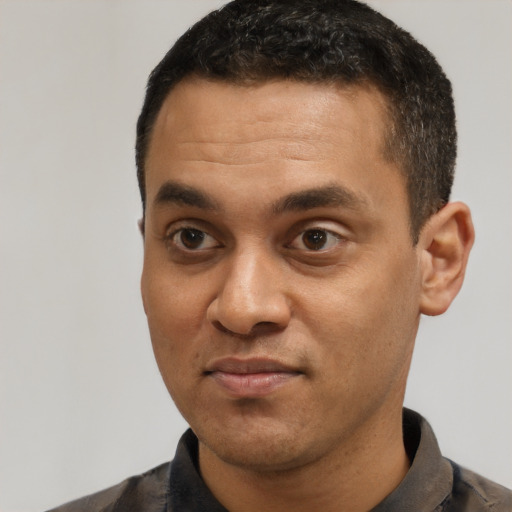 Joyful black young-adult male with short  black hair and brown eyes