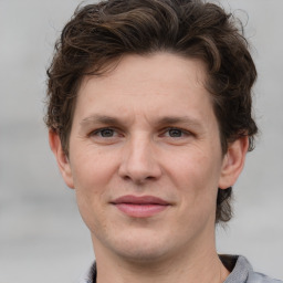 Joyful white adult male with short  brown hair and grey eyes