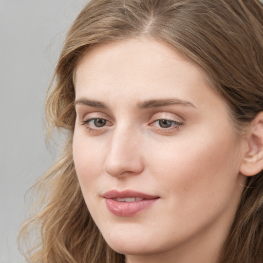 Joyful white young-adult female with long  brown hair and blue eyes