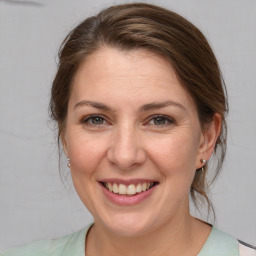 Joyful white adult female with medium  brown hair and grey eyes