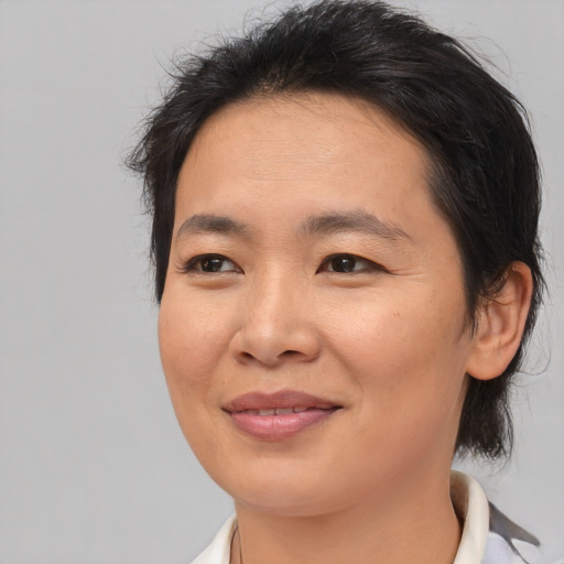 Joyful asian adult female with medium  brown hair and brown eyes
