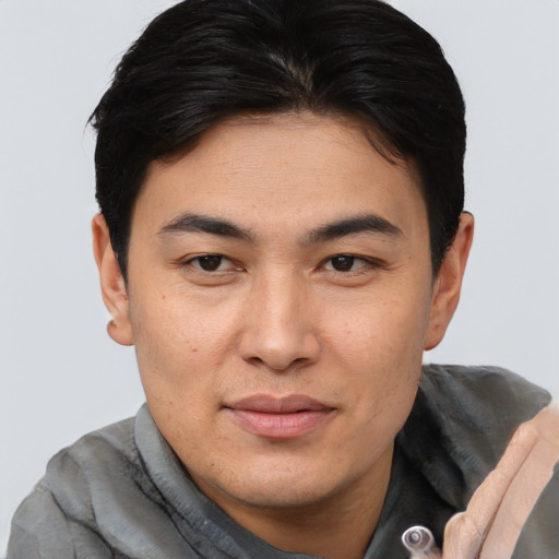 Joyful asian young-adult male with short  brown hair and brown eyes