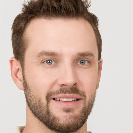 Joyful white young-adult male with short  brown hair and grey eyes