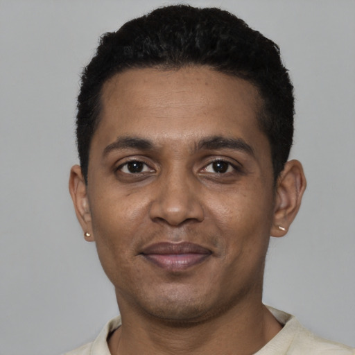 Joyful black young-adult male with short  black hair and brown eyes