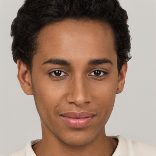 Joyful black young-adult male with short  brown hair and brown eyes