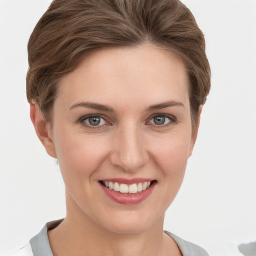 Joyful white young-adult female with short  brown hair and grey eyes