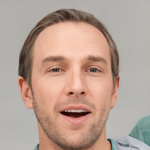 Joyful white young-adult male with short  brown hair and grey eyes