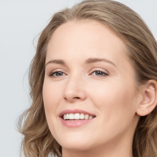 Joyful white young-adult female with long  brown hair and blue eyes