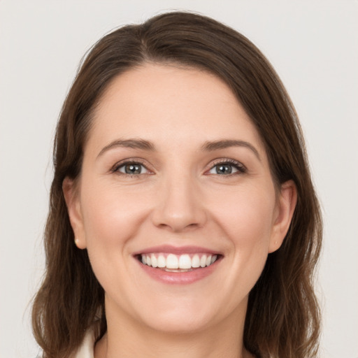 Joyful white young-adult female with medium  brown hair and grey eyes