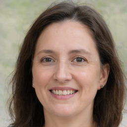 Joyful white adult female with medium  brown hair and brown eyes