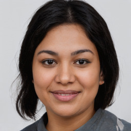 Joyful latino young-adult female with medium  brown hair and brown eyes